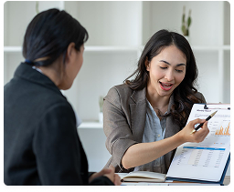 Two colleagues reviewing a financial report on a clipboard