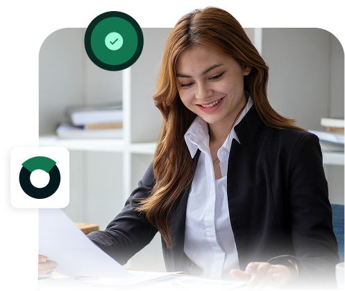 Bookkeeper smiling while reviewing financial documents at her desk