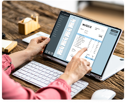 Processing payroll and invoices in accounting software on a laptop
